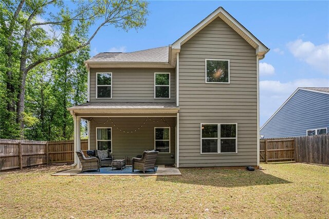 rear view of property with a lawn, an outdoor hangout area, and a fenced backyard