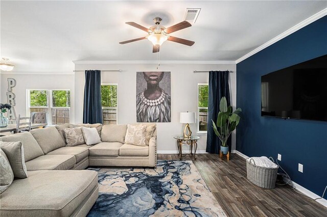 living room featuring ceiling fan, visible vents, crown molding, wood finished floors, and baseboards