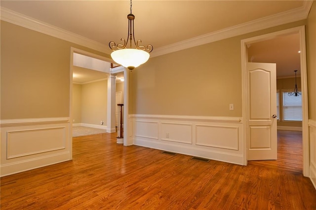 spare room featuring wood-type flooring and ornamental molding