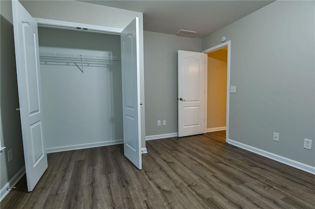 unfurnished bedroom featuring a closet and dark hardwood / wood-style floors