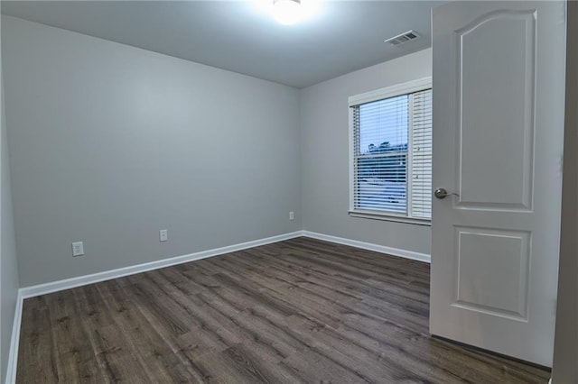 spare room featuring dark wood-type flooring