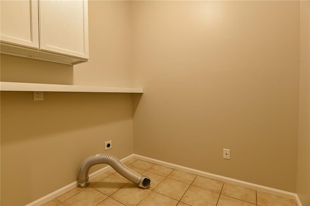 laundry room featuring cabinets, light tile patterned flooring, and hookup for an electric dryer