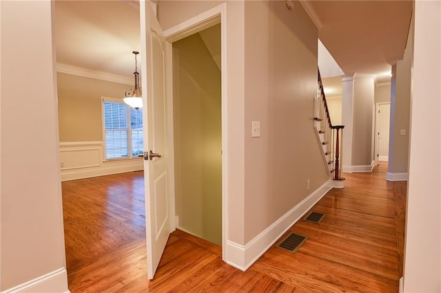 corridor featuring wood-type flooring and ornamental molding