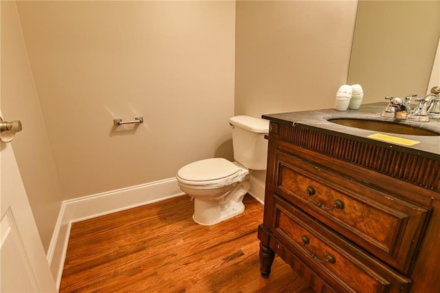 bathroom with vanity, toilet, and hardwood / wood-style floors