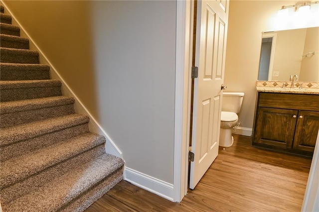 stairs featuring sink and hardwood / wood-style flooring