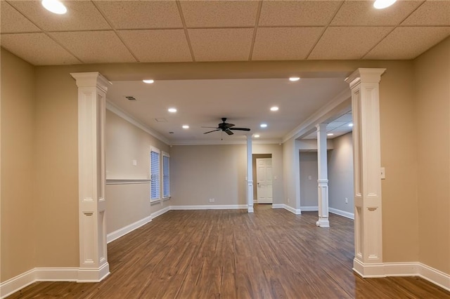 spare room featuring dark wood-type flooring, ceiling fan, crown molding, and decorative columns