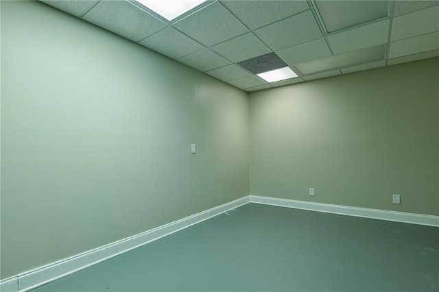 spare room featuring concrete flooring and a drop ceiling