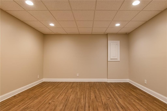 unfurnished room with wood-type flooring and a paneled ceiling