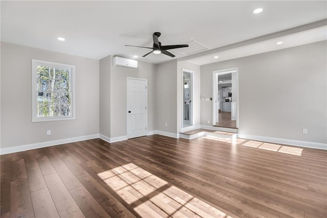 unfurnished room with recessed lighting, baseboards, an AC wall unit, and wood finished floors