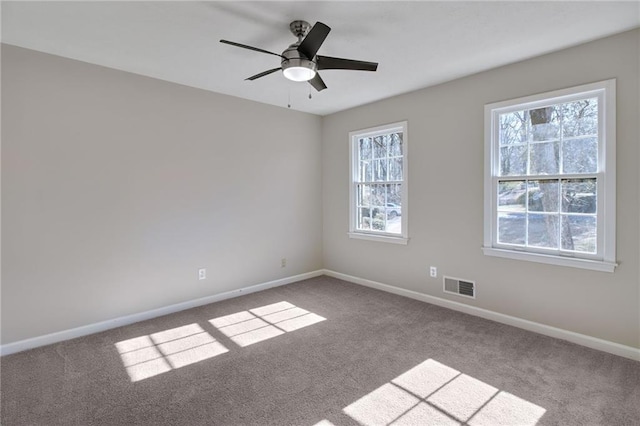 spare room featuring a ceiling fan, carpet, visible vents, and baseboards