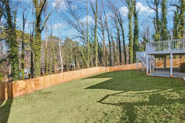 view of yard featuring a fenced backyard, a patio, a deck, and stairs