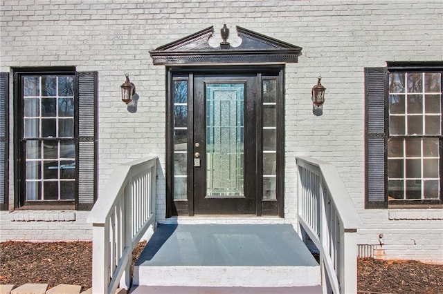 entrance to property featuring brick siding