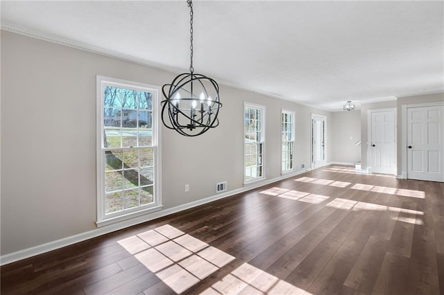 unfurnished dining area with crown molding, dark wood-style flooring, a notable chandelier, and baseboards