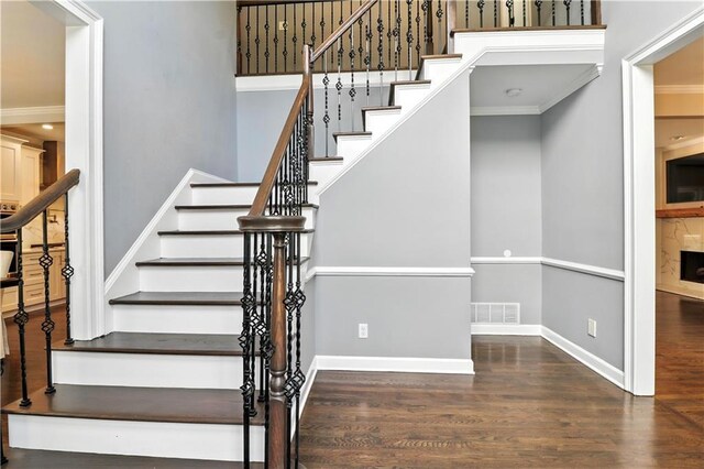 5807 Brookstone Walk NW, Acworth, GA 30101 - staircase featuring wood finished floors, ornamental molding, and a fireplace