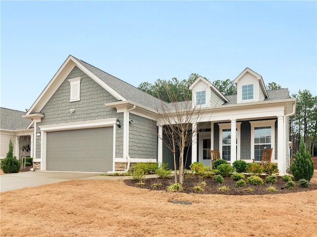 view of front of property featuring a garage, driveway, and covered porch