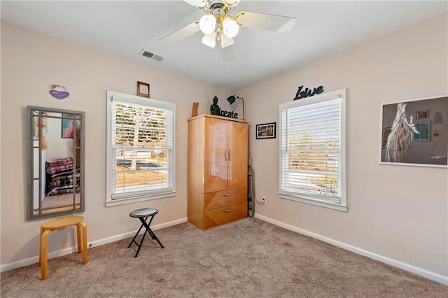 interior space featuring ceiling fan, carpet flooring, visible vents, and baseboards