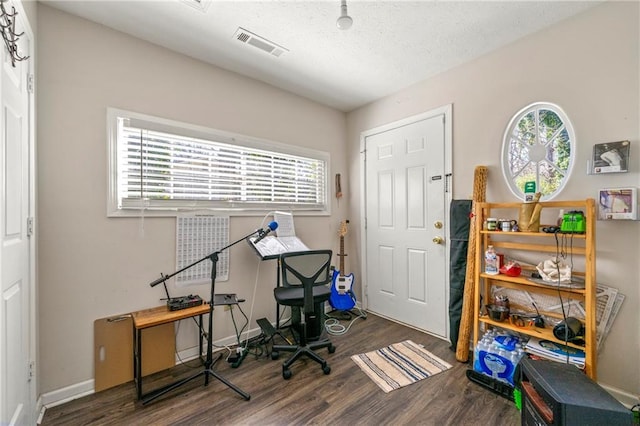 home office featuring visible vents, a textured ceiling, baseboards, and wood finished floors