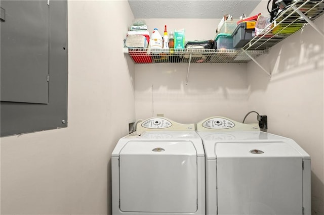 washroom with laundry area, electric panel, a textured ceiling, and washing machine and clothes dryer