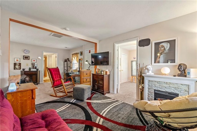 carpeted living area featuring a fireplace and visible vents