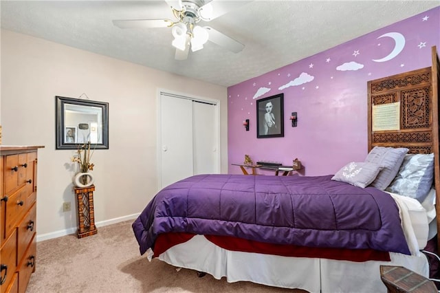 bedroom featuring carpet, a closet, a ceiling fan, a textured ceiling, and baseboards