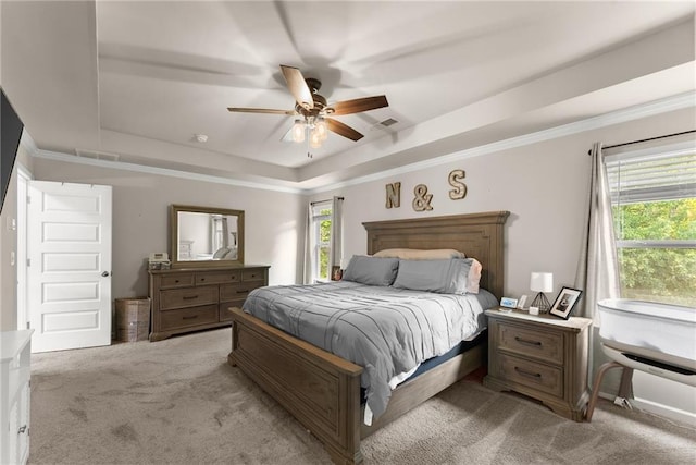 bedroom with a tray ceiling, carpet floors, multiple windows, and ceiling fan