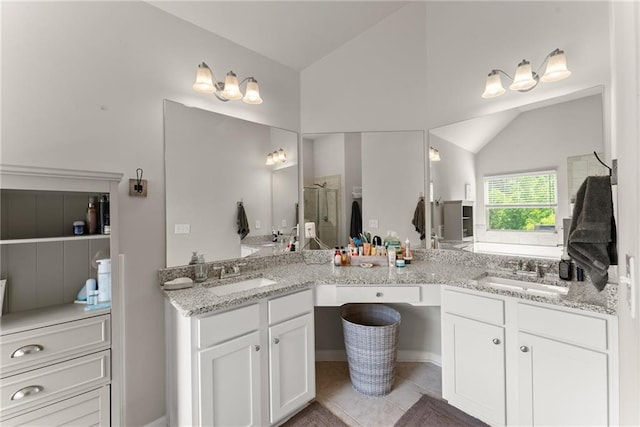 full bathroom featuring vaulted ceiling, a shower stall, double vanity, and tile patterned flooring