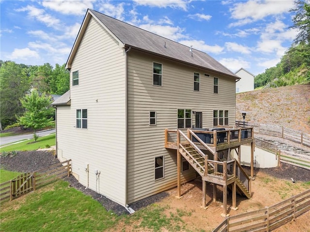 rear view of house featuring stairs, a deck, and a fenced backyard