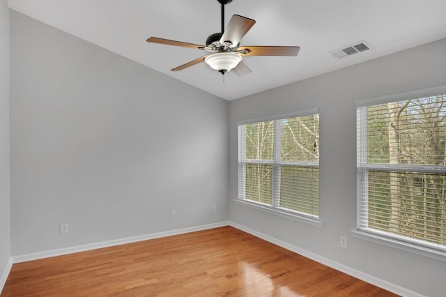 unfurnished room with light wood finished floors, baseboards, visible vents, and a ceiling fan