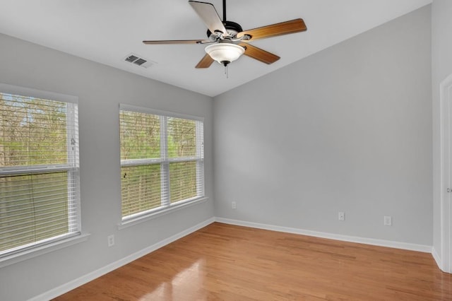 spare room featuring light wood-type flooring, baseboards, visible vents, and ceiling fan