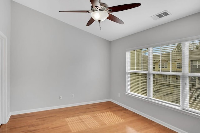 spare room with light wood-style floors, plenty of natural light, visible vents, and baseboards