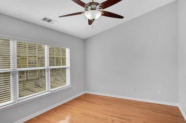 empty room with a ceiling fan, light wood-style flooring, visible vents, and baseboards