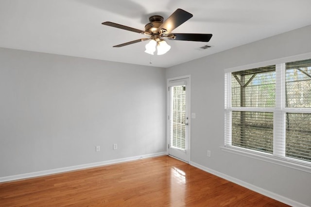 spare room featuring a ceiling fan, light wood-style flooring, visible vents, and baseboards