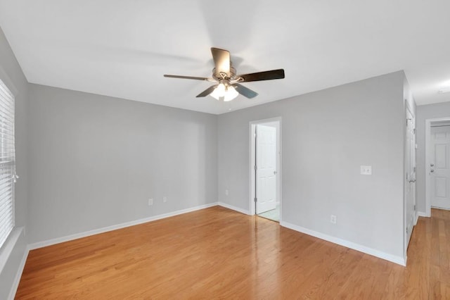 unfurnished room with ceiling fan, light wood-type flooring, and baseboards