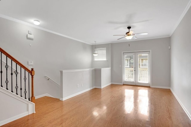 unfurnished room with ceiling fan, baseboards, french doors, light wood-type flooring, and crown molding