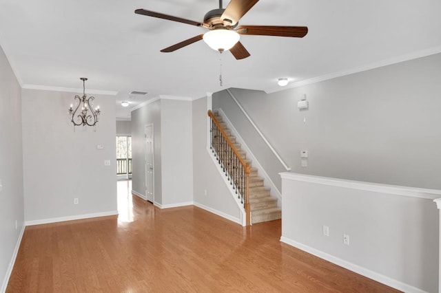 unfurnished living room featuring stairway, baseboards, and wood finished floors