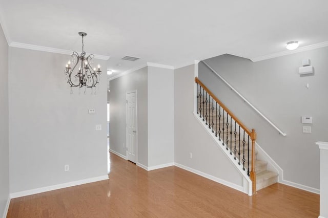 interior space featuring wood finished floors, visible vents, baseboards, stairway, and crown molding