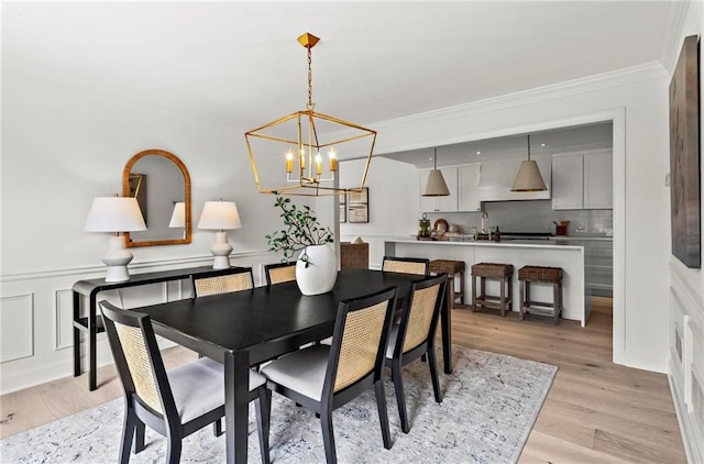 600 Delphinium Blvd NW, Acworth, GA 30102 - dining area featuring a chandelier, crown molding, light wood finished floors, a wainscoted wall, and a decorative wall