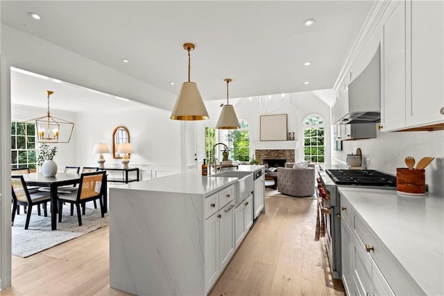 600 Delphinium Blvd NW, Acworth, GA 30102 - kitchen featuring stainless steel stove, light wood-style floors, light countertops, a sink, and decorative light fixtures