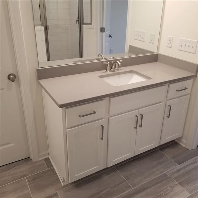 bathroom featuring vanity and a shower with shower door