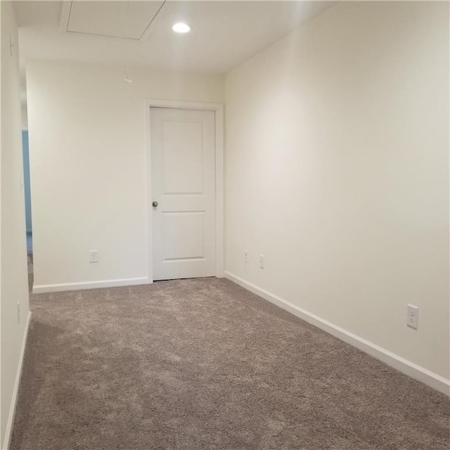 spare room featuring dark colored carpet