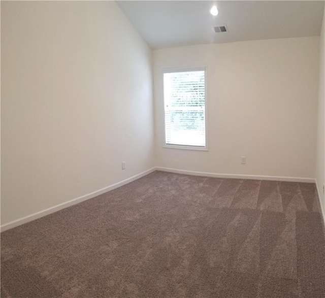 carpeted spare room with lofted ceiling