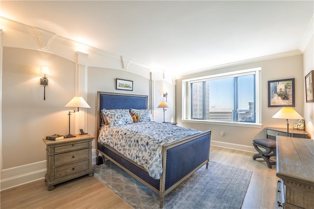 bedroom featuring crown molding, baseboards, and wood finished floors