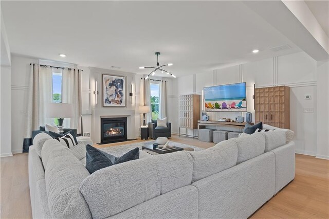 living room with light hardwood / wood-style flooring and a chandelier