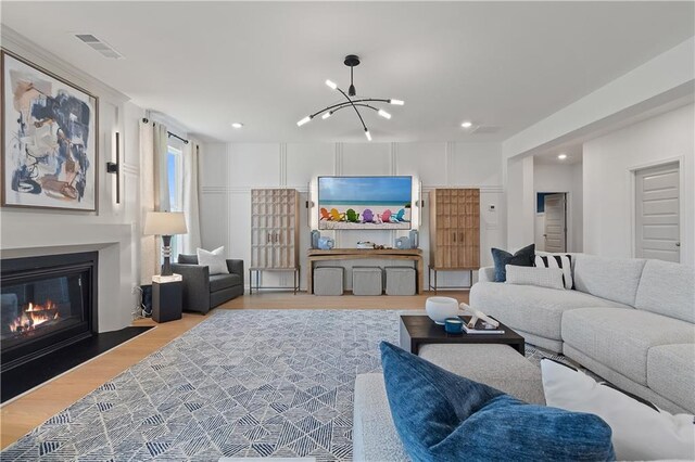 living room with light hardwood / wood-style flooring and an inviting chandelier