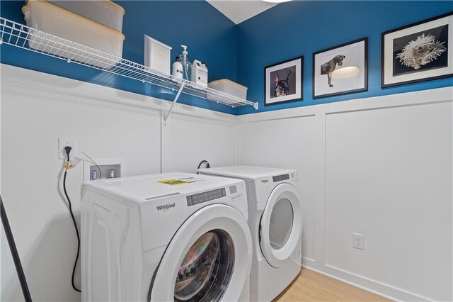 clothes washing area featuring light wood-type flooring and washer and dryer