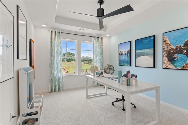 office with a tray ceiling, ceiling fan, and light colored carpet