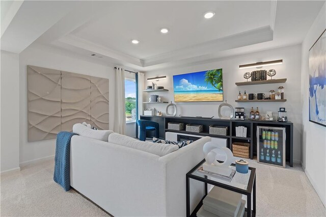 carpeted living room featuring a raised ceiling and indoor bar