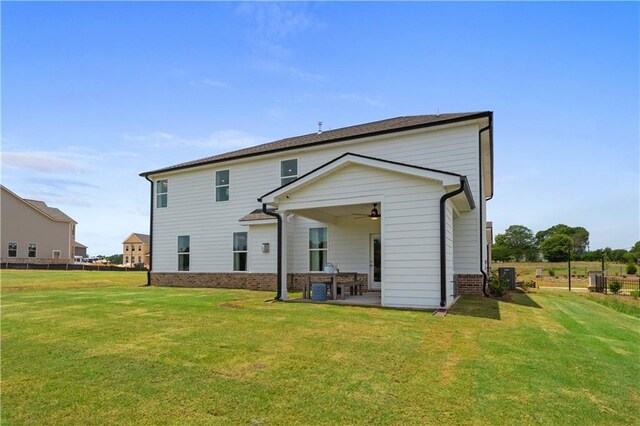 rear view of property with a lawn, a patio, and ceiling fan