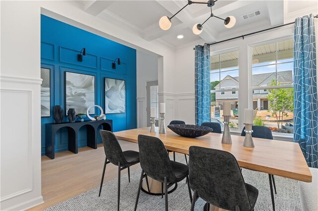 dining space featuring crown molding, coffered ceiling, beam ceiling, and hardwood / wood-style floors