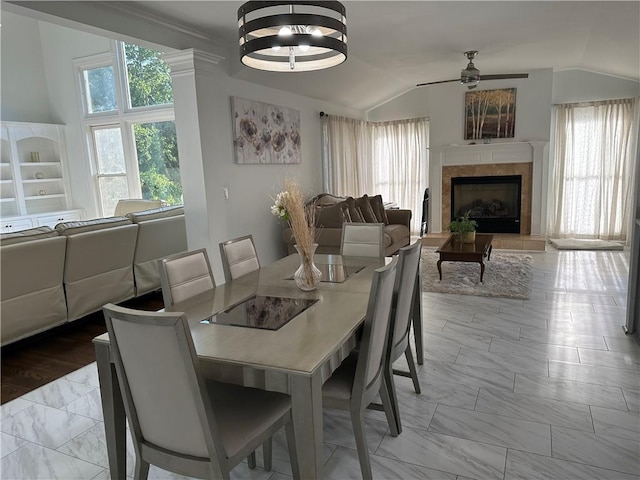 dining room featuring a fireplace, lofted ceiling, a ceiling fan, and marble finish floor